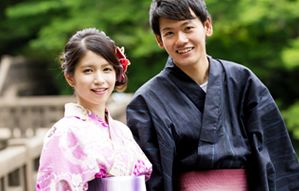 緑をバックに微笑む和装男女